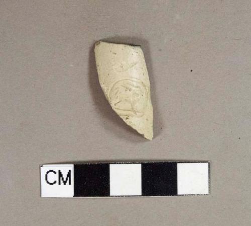 Smoked kaolin pipe bowl fragment with cartouche of an animal, possibly a gryphon