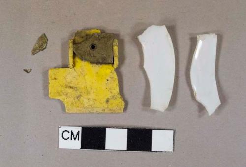 Two white plastic fragments, one possibly part of a plastic spoon; one yellow plastic fragment with metal piece attached to it