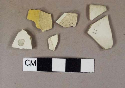 Three creamware body sherds; one staffordshire slipware body sherd; one thin-bodied white stoneware body sherd with possible black decoration; one thin-bodied white stoneware rim sherd; thin-bodied white stoneware sherds crossmend