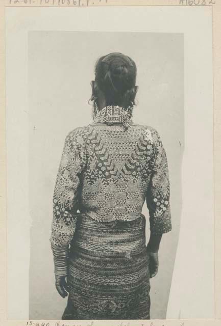 Bagobo woman in dress with elaborate bead work, back