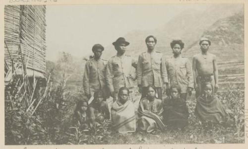 Industrial teachers in the Banaue Ifugao Industrial School standing, with their wives sitting in front of them