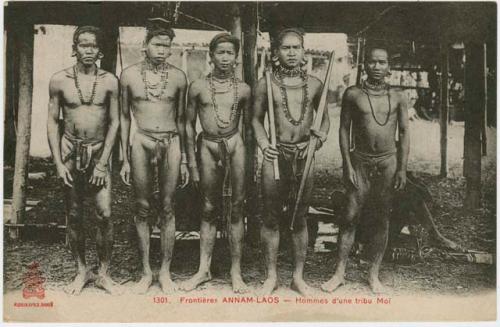 Group of men standing in front of a structure