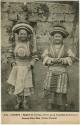 Two children standing in front of a wall