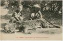 Two men with dead tiger on carrier