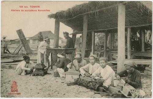 People woodworking in front of a shelter