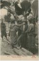 Women standing next to banana tree, man standing in background