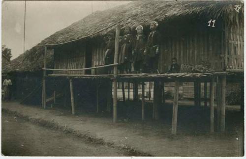 Group of women and a child standing on a platform in front of a structure