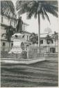 Fenced in statue in front of building