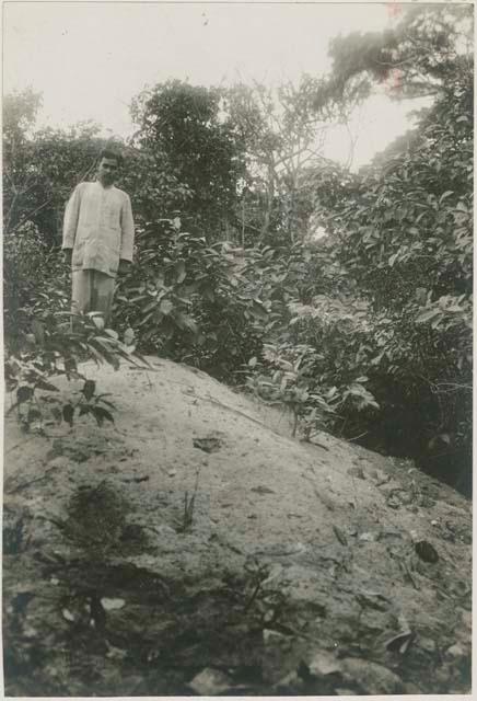 Man on hill in front of trees