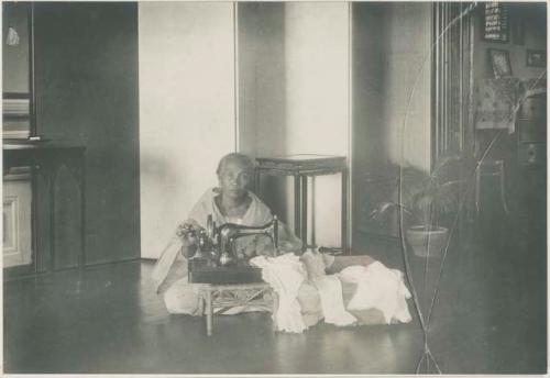 Woman in house with Singer sewing machine