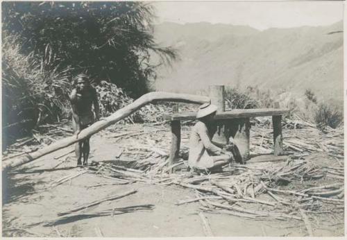 Two people beside wooden structure