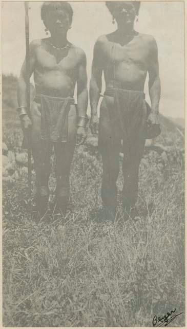 Priest (right) standing with another man