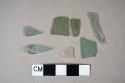 One colorless bottle glass fragment; six aqua flat glass fragments, two crossmend
