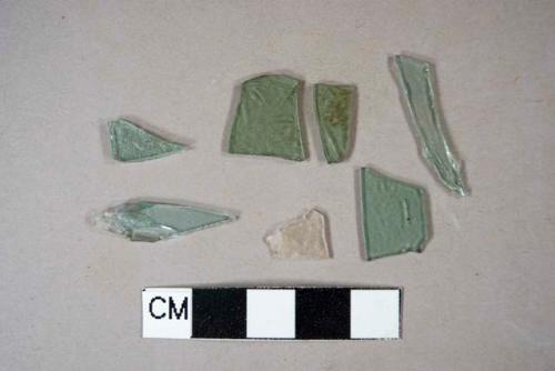 One colorless bottle glass fragment; six aqua flat glass fragments, two crossmend