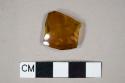 Amber vessel glass body fragment, likely shoulder fragment