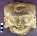Cast of "laughing face" - scroll design in bas relief on forehead
