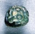Portion of carved jadeite object, piece of carved nose button,