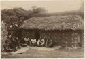 Fijian chiefs sitting on mats outside a structure