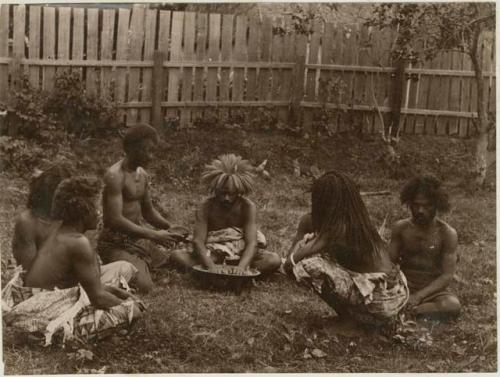 Fijians sitting outside making kava