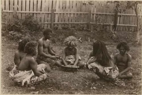 Fijians sitting outside making kava