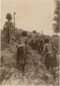 Armed Fijian men marching away from photographer