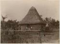 Thatched mountain house with people in front