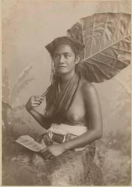 Studio portrait of a woman holding a large leaf