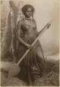 Fijian girl from the reefs, in a studio-staged scene, holding a wooden paddle