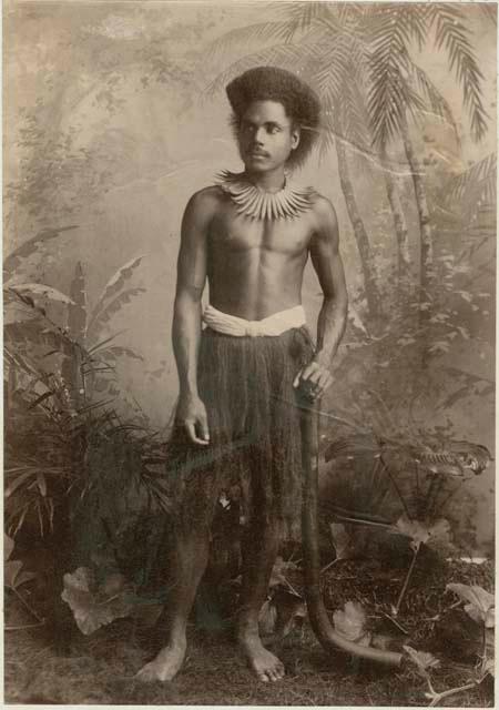 Fijian man in a studio-staged scene, holding a club