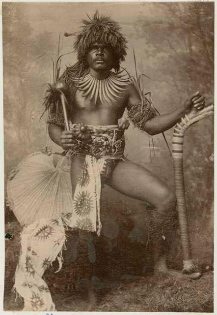 Fijian man in a studio-staged scene, holding a club