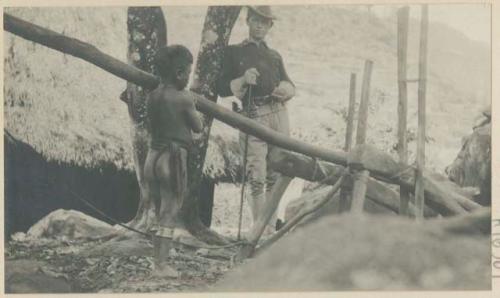 Chilid standing next to a sugar mill for extracting the juice from sugar cane, with Jeff D. Gallman standing in the background