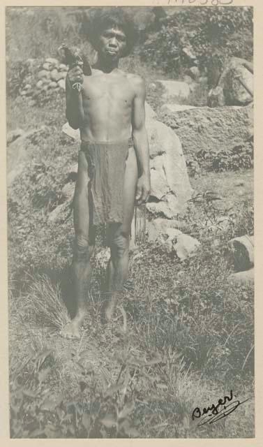 Man holding a bird he has caught, after it has been chased by people on the terraces in the valley