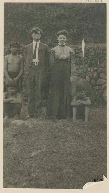 Man standing and two boys sitting next to H. I. Harlan and his wife, an American couple