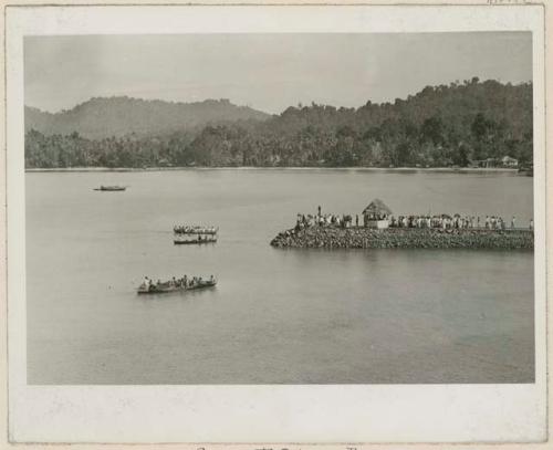 People in boats and on jetty