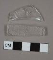 Colorless bottle glass fragments; one is molded with textured surface, one is embossed with possible letter "s"