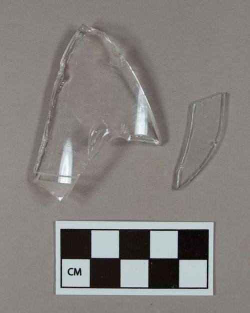 One fragment of flat aqua glass; one fragment of colorless bottle glass with etched lines