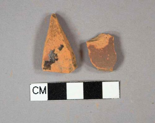 Redware vessel body fragments, 1 painted dark brown, 1 dark brown slip-glazed, undecorated