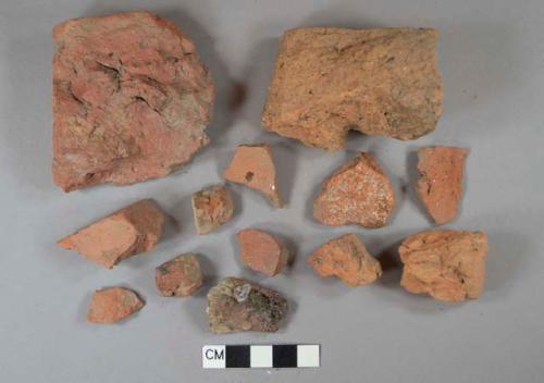 Red brick fragments, 1 burned, 1 dark red slip-glazed redware vessel body fragment