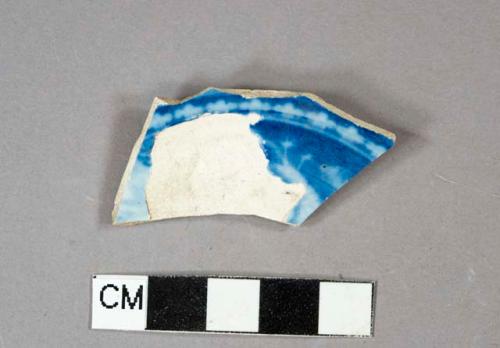 Blue on white flow-blue decorated pearlware vessel base fragment with foot ring