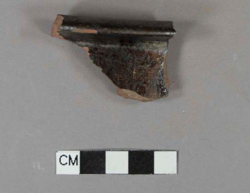 Undecorated lead glazed redware rim sherd, possible chamber pot