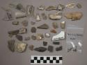 20 bone; 7 pottery; 13 glass; 13 chipping waste; 5 coal; biface fragment - perfo