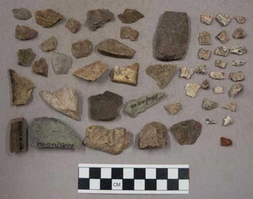 83 small stone bits and chips; 13 small bone fragments; 2 larger stone pieces; 3