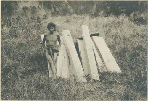 Igorot man posed with timber to build houses