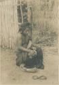 Igorot girl making thread from bark fiber