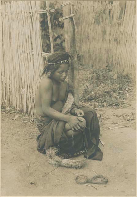 Igorot girl making thread from bark fiber