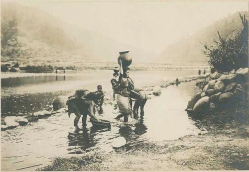 Igorot women carrying water at the river