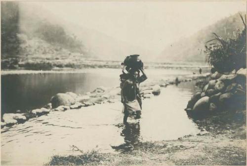 Igorot women carrying water at the river