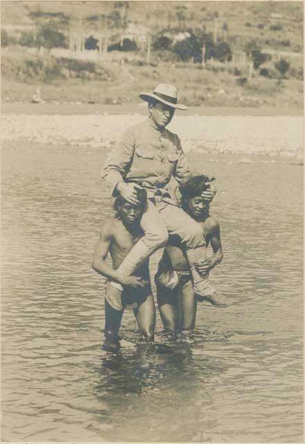 Two Bontoc Igorot men holding Dr. Jenks on their shoulders