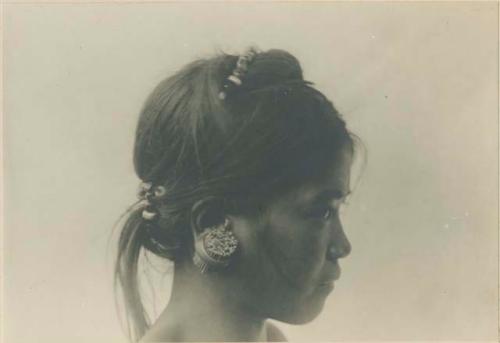 Bontoc Igorot girl, showing method emplyed in expanding opening in lobe of the ear