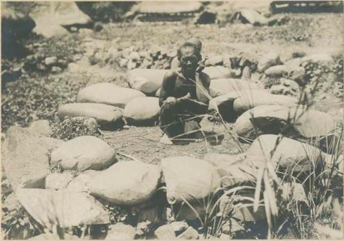 Igorot man with foundation of a house built by Lumawig, the God of Bontoc